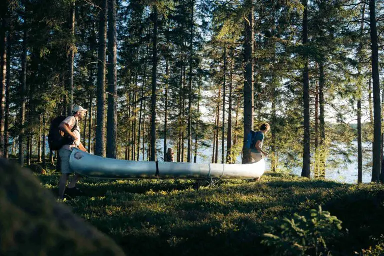 Two friends into the wood with their canoe