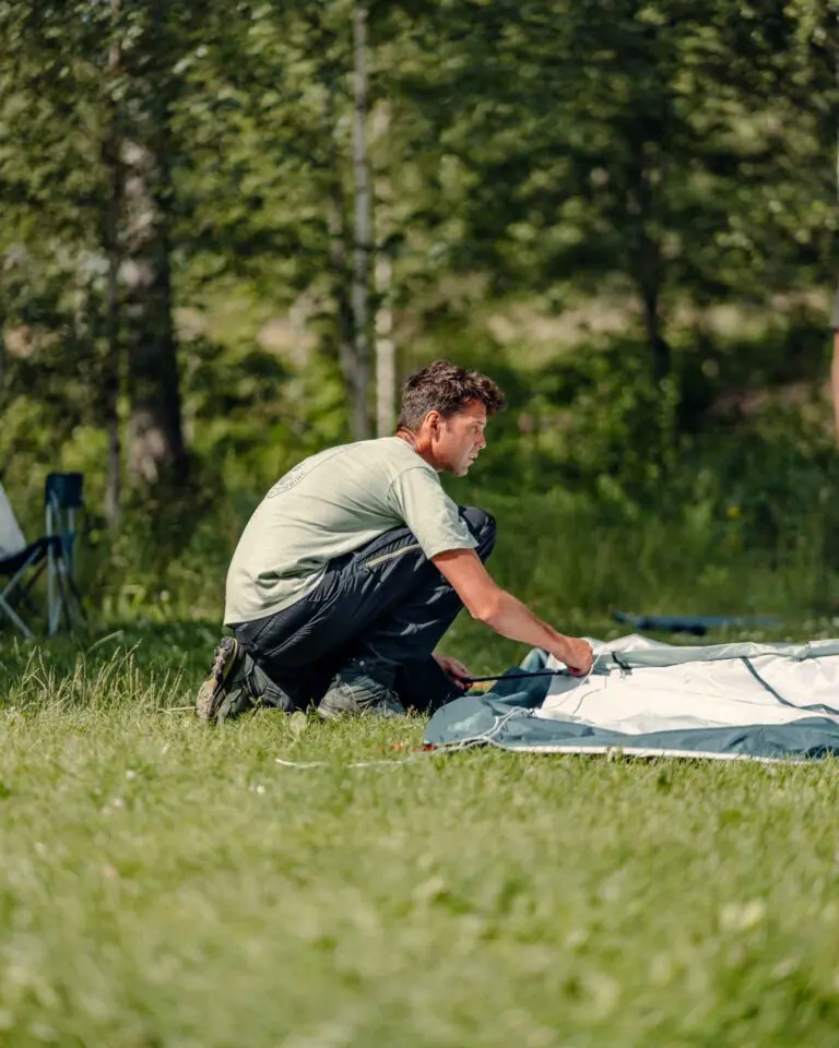 Un participant en train de monter sa tente pour bivouaquer en Suède.