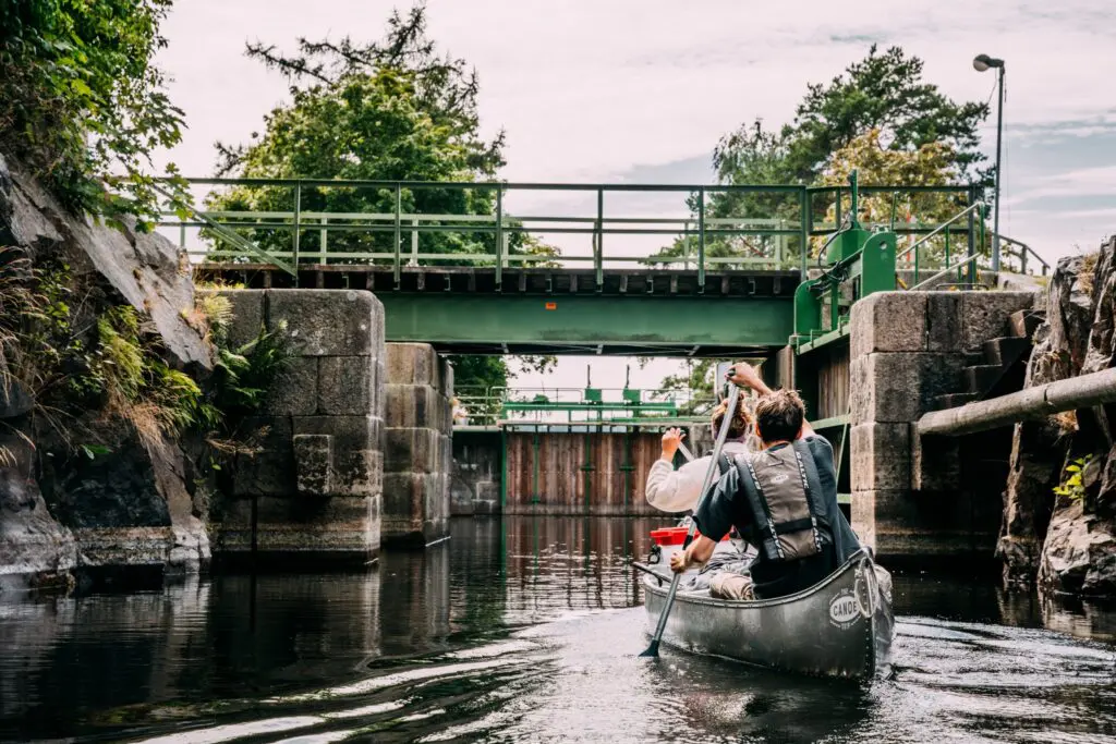 two people canoeing through a canal lock system